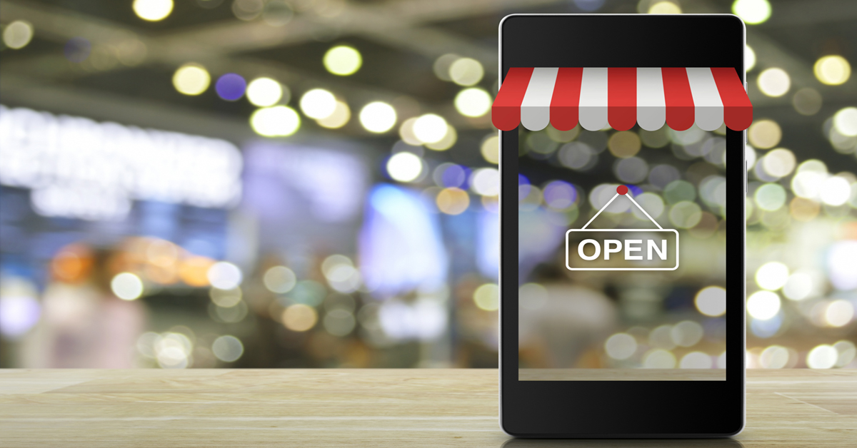 Cell phone showing image of storefront with "Open" sign representing the retail experience