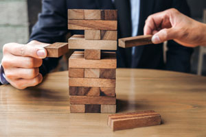 Hands of two people playing Jenga as metaphor for marketing officer integration in C-Suite